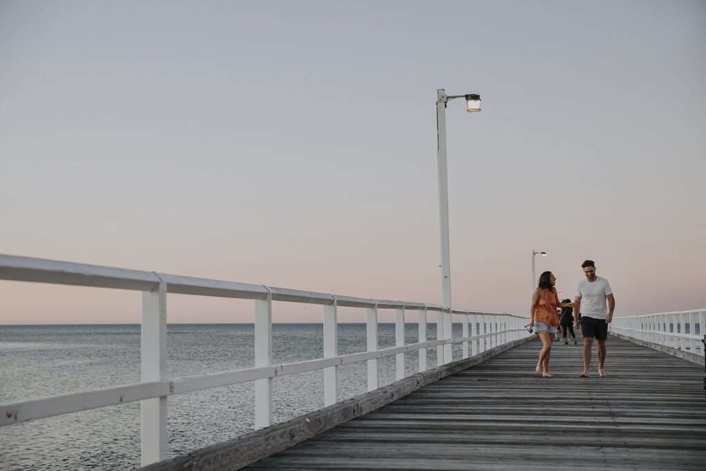 Urangan Pier couple walking at sunset | Tasman Holiday Parks