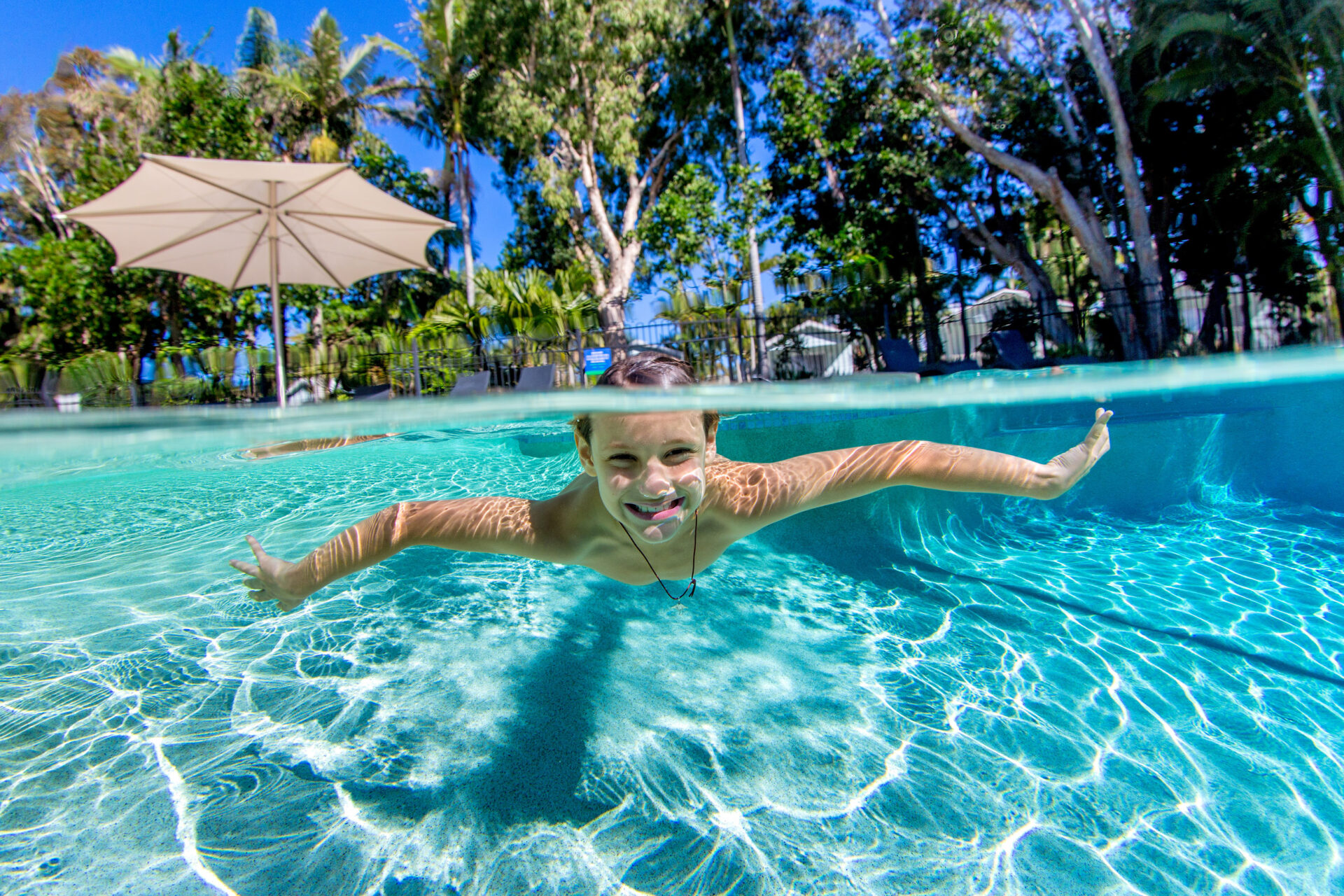 Boy swimming in the pool | Tasman Holiday Parks - Ballina