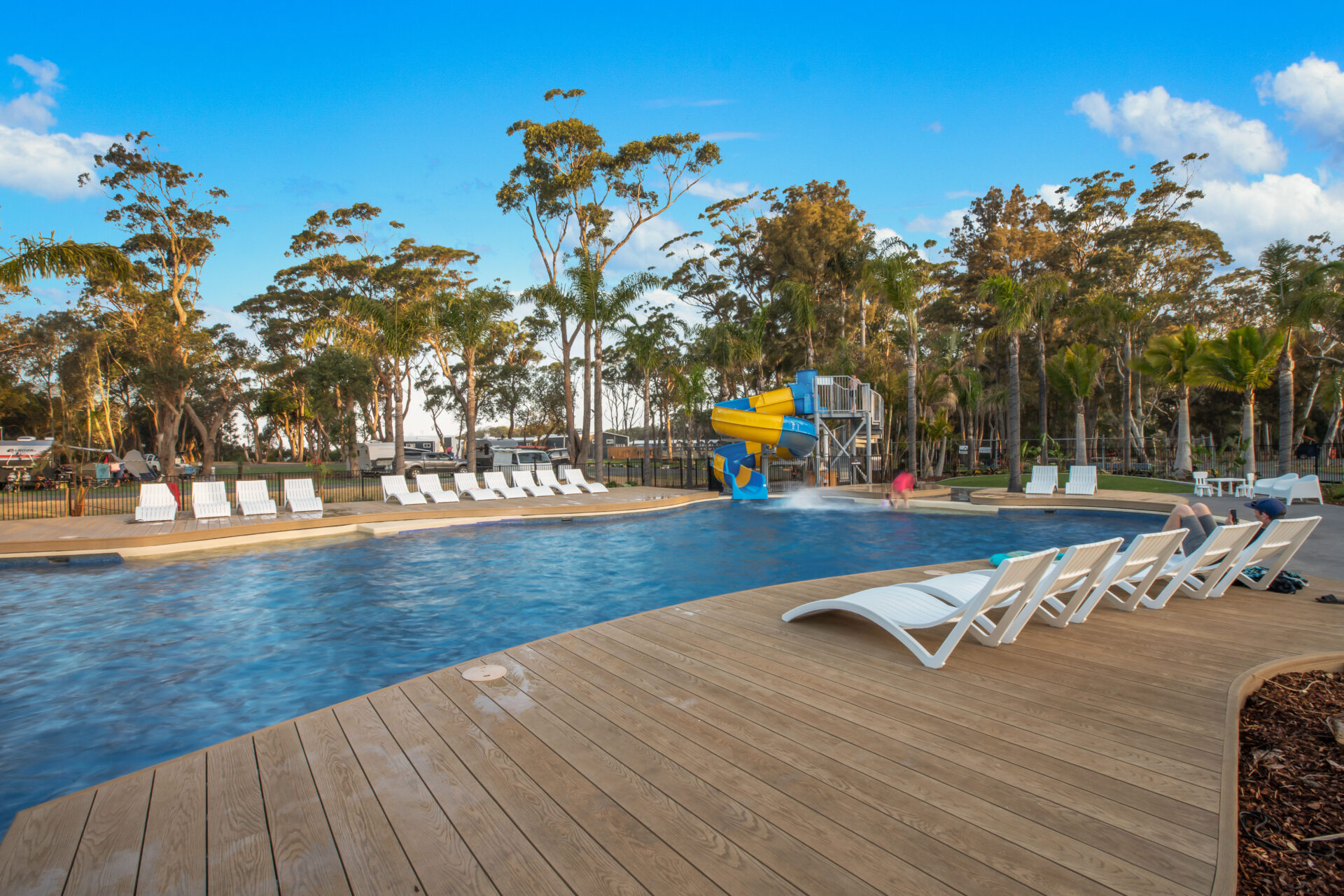 Swimming pool with sun loungers and waterslide | Tasman Holiday Parks Racecourse Beach