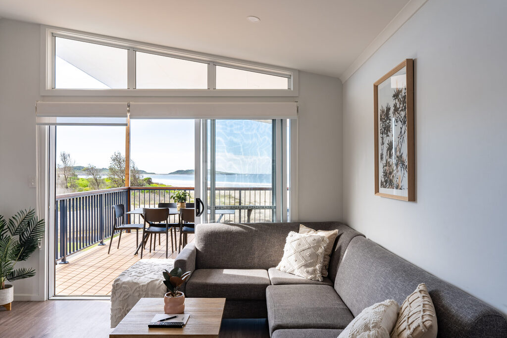 Premium beachfront cabin living room looking out over the balcony with ocean views | Tasman Holiday Parks Racecourse Beach Bawley Point accommodation