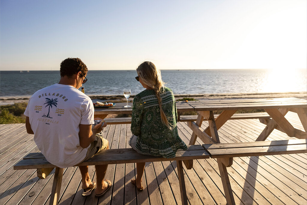 Couple watching the sunset by the sea | Tasman Holiday Parks Denham Seaside
