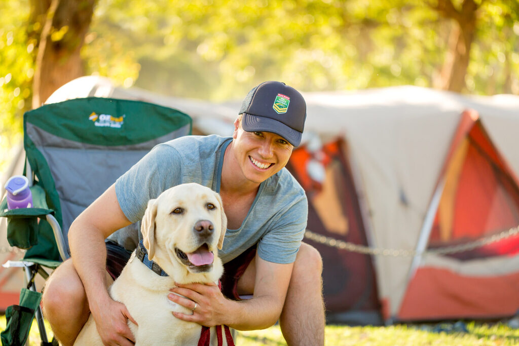 Woman and dog in front of tents camping pet friendly | Tasman Holiday Parks Kioloa Beach