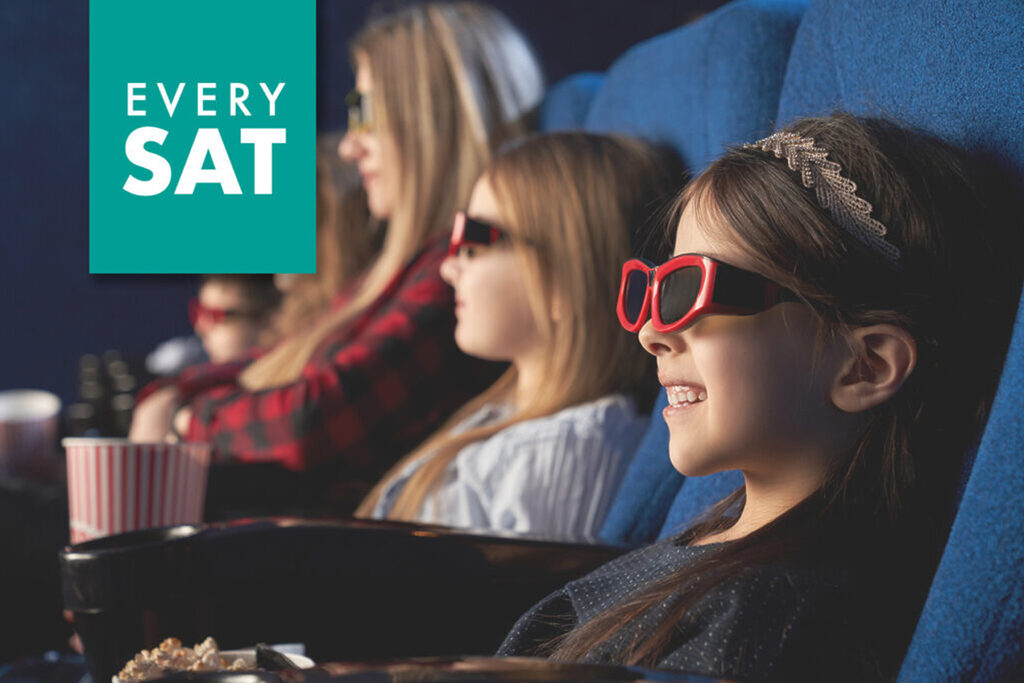 A group of children and adults wearing 3D glasses sit in a row of blue cinema seats, enjoying a movie. Popcorn and drinks can be seen on the armrests. A teal banner in the top left corner reads "EVERY SAT.