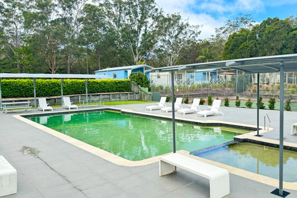 Swimming pool and toddler pool with sun loungers and shade at Tasman Holiday Parks Myola