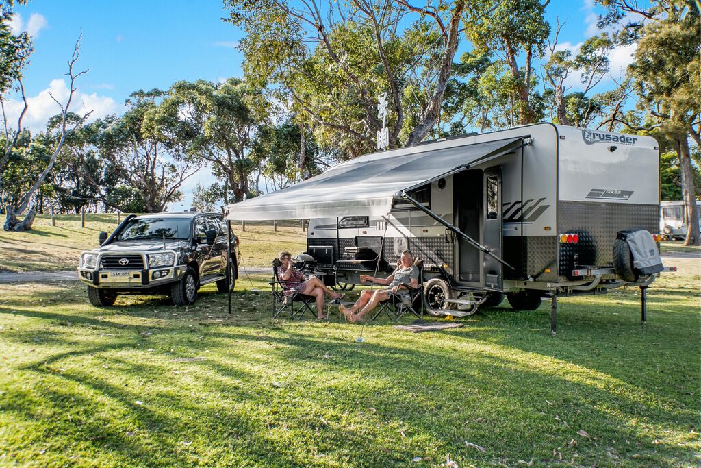 Unpowered camping caravan site with trees | Tasman Holiday Parks Kioloa Beach