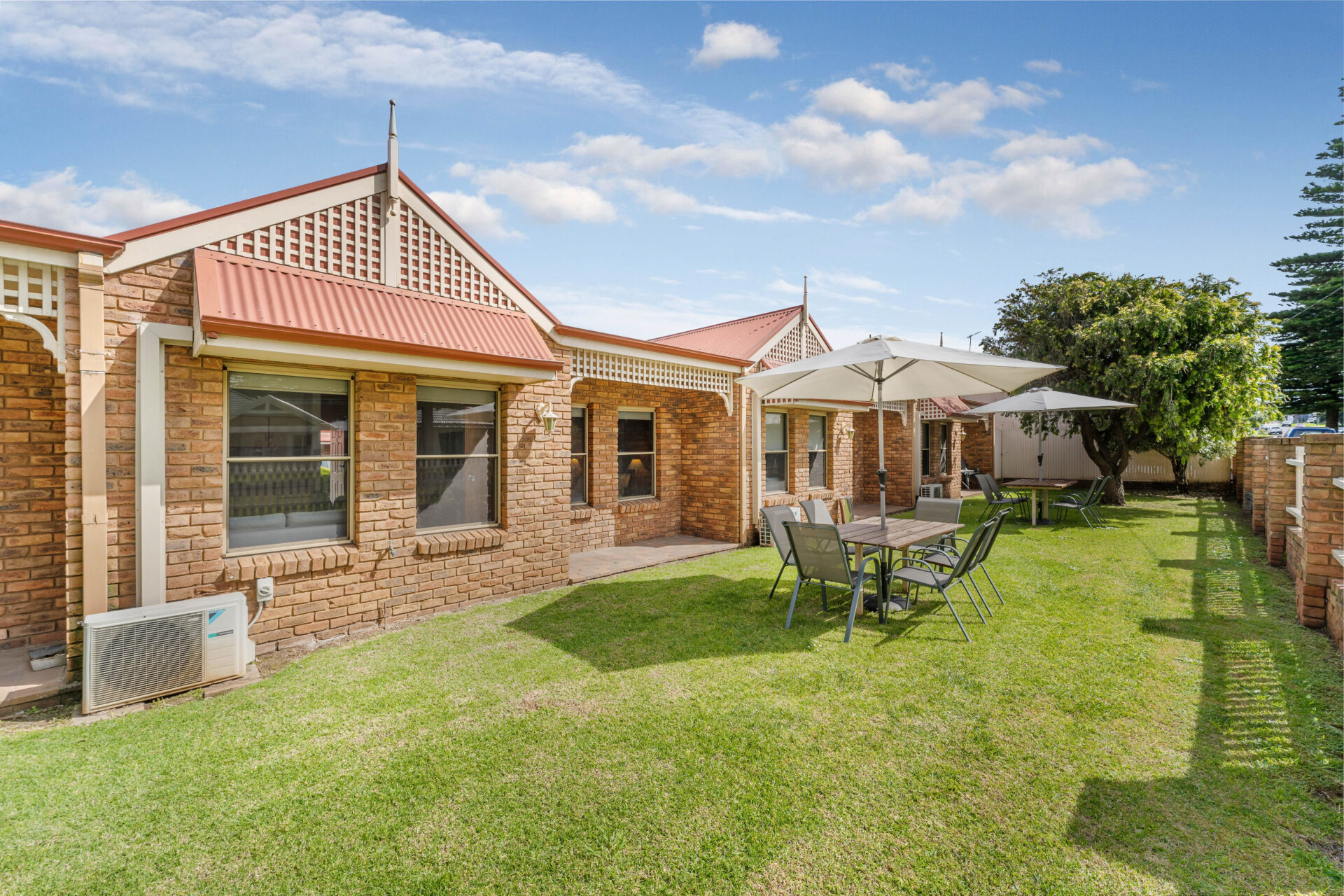 Standard cabin 2 bedroom exterior featuring outdoor table and umbrella | Tasman Holiday Parks Warrnambool