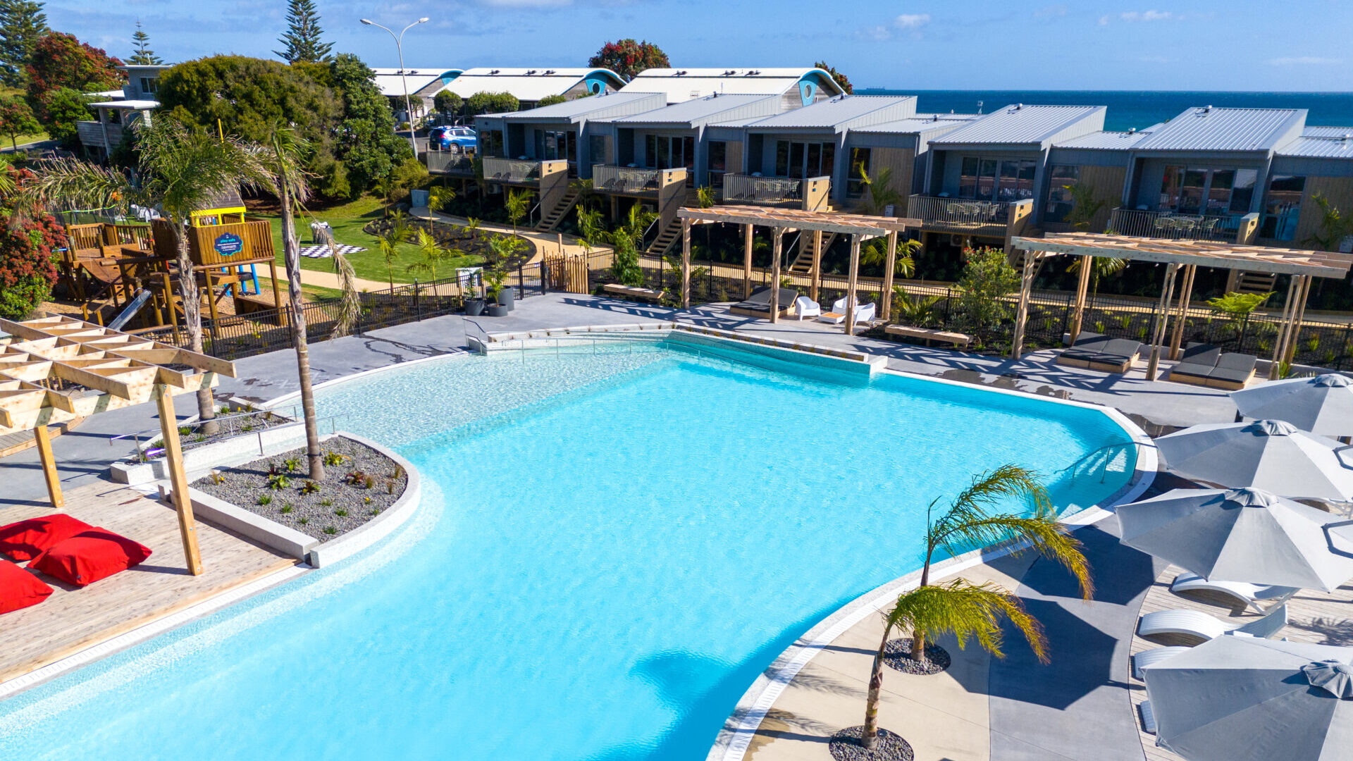 Papamoa Beach aerial showcasing pool and villas | Tasman Holiday Parks Papamoa Beach