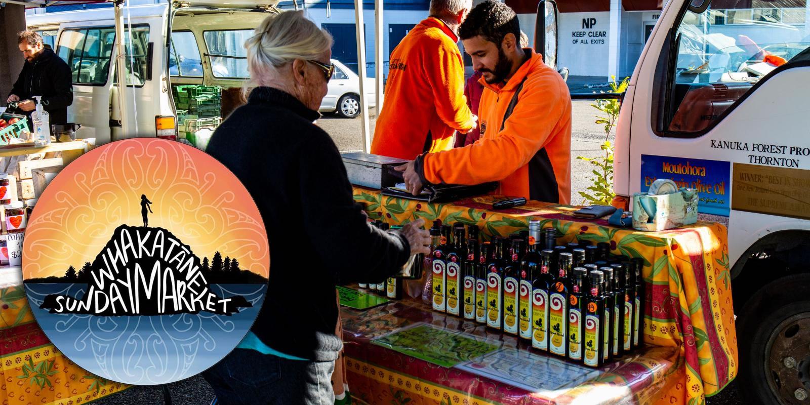 An outdoor market scene with a vendor wearing an orange jacket selling products to an older woman. A logo reads "Whakatane Sunday Market" with a sunburst design. Various bottles and items are displayed on the vendor's stall. Other people and market stalls are visible in the background.